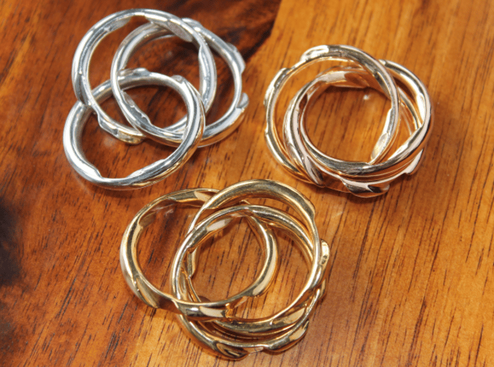 Three Phase Puzzle Ring 3d printed Interlocking Silver, Bronze, and Brass in the scrambled state.