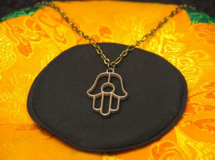 Hamsa Pendant 3d printed Photo of Stainless Steel pendant on a chain.
