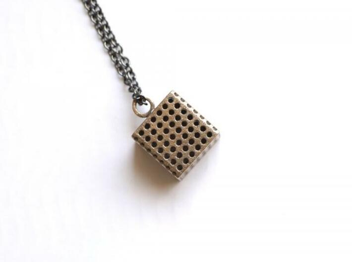 Perforated Cube Pendant  3d printed steel cube against white background