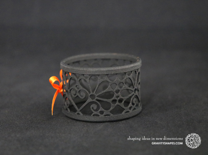 A large napkin ring with Mosaic-3b 3d printed The photo shows a print made of black strong and flexible incl. orange lacing.