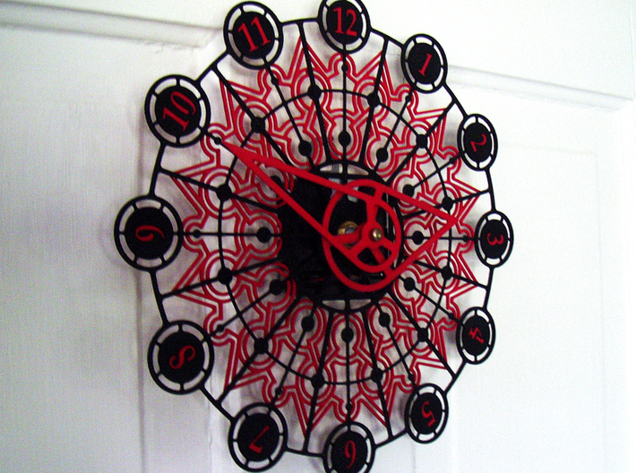 Kaleidoscope Clock - Part A 3d printed The completed Kaleidoscope Clock with Part A in Black Strong & Flexible and Part B in Red Strong & Flexible.This is a two-part clock face kit. This model is Part A. The second part is available at http://www.shapeways.com/model/580493