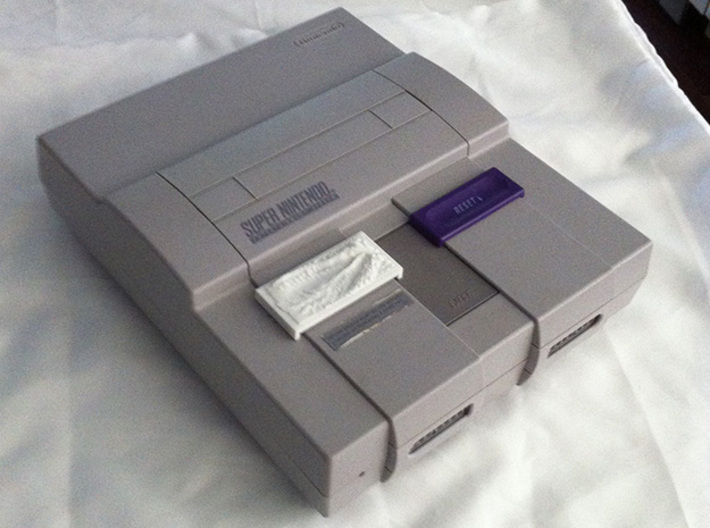 DragonMouth Plastic Power/Reset Button Cover 3d printed The cover in use on an SNES unit.