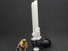 Action Figure Chainsword - Left Handed 3d printed Printed in White Natural Versatile Plastic, held by the hand of a 1:12 scale action figure arm, with a 28mm heroic scale model