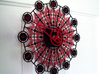 Kaleidoscope Clock - Part A 3d printed The completed Kaleidoscope Clock with Part A in Black Strong & Flexible and Part B in Red Strong & Flexible.This is a two-part clock face kit. This model is Part A. The second part is available at http://www.shapeways.com/model/580493